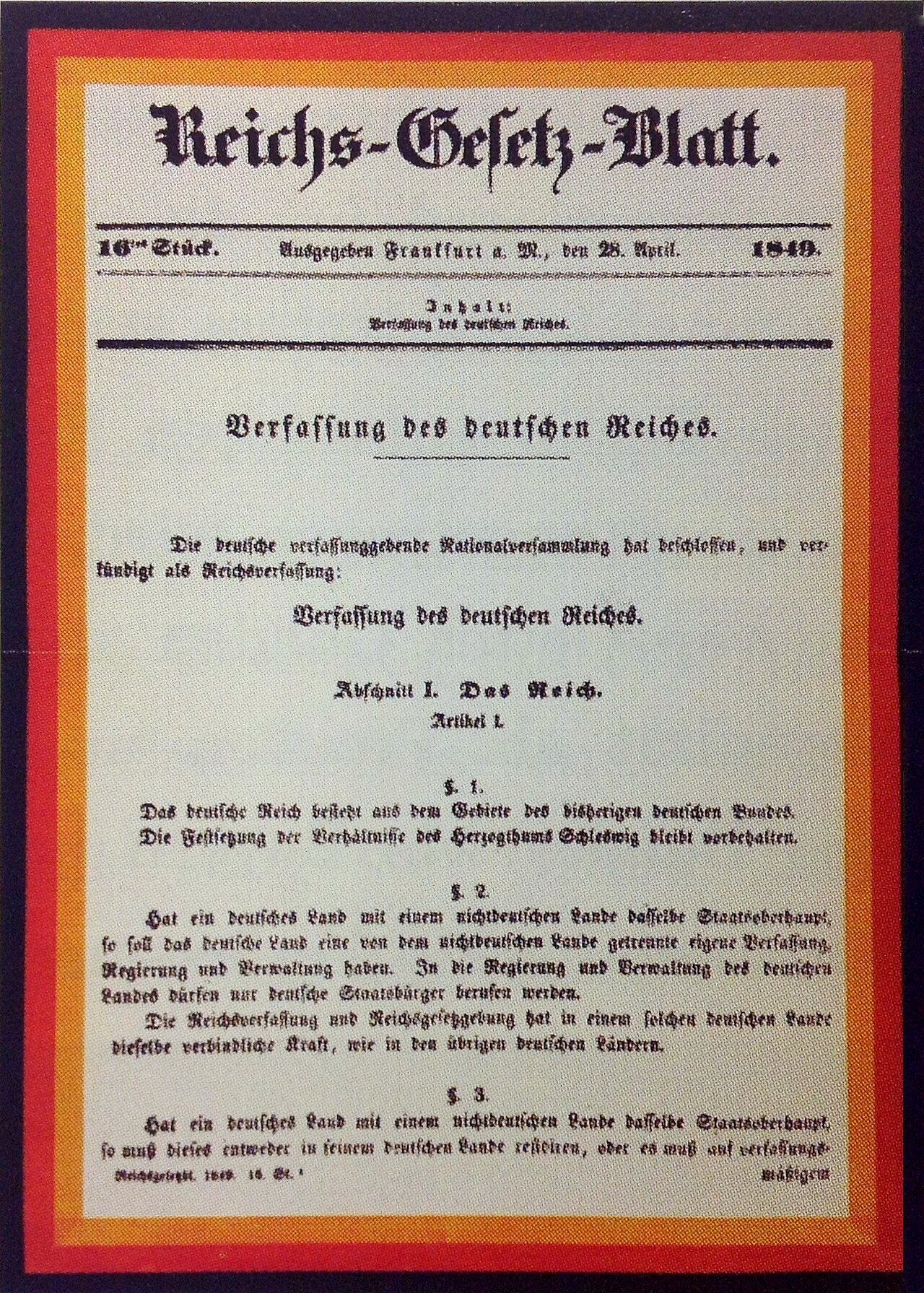 Reichsgesetzblatt mit Reichsverfassung Farbfoto: Dokument mit schwarz-rot-goldenem Rand und altdeutschem Text.