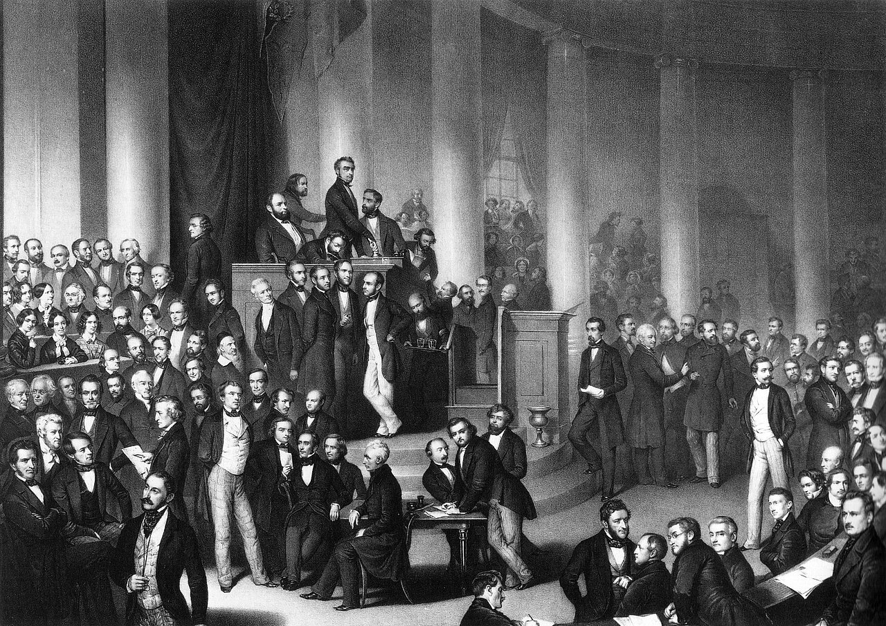 Lithographie, Eduard Meyer, 1848. “Die Deutsche Nationalversammlung in der Paulskirche”. Foto: Unknown source, CC0, via Wikimedia Commons; https://upload.wikimedia.org/wikipedia/commons/1/1d/Bilderrevolution0408.jpg Lithographie, Eduard Meyer, 1848. “Die Deutsche Nationalversammlung in der Paulskirche”. Foto: Unknown source, CC0, via Wikimedia Commons; https://upload.wikimedia.org/wikipedia/commons/1/1d/Bilderrevolution0408.jpg